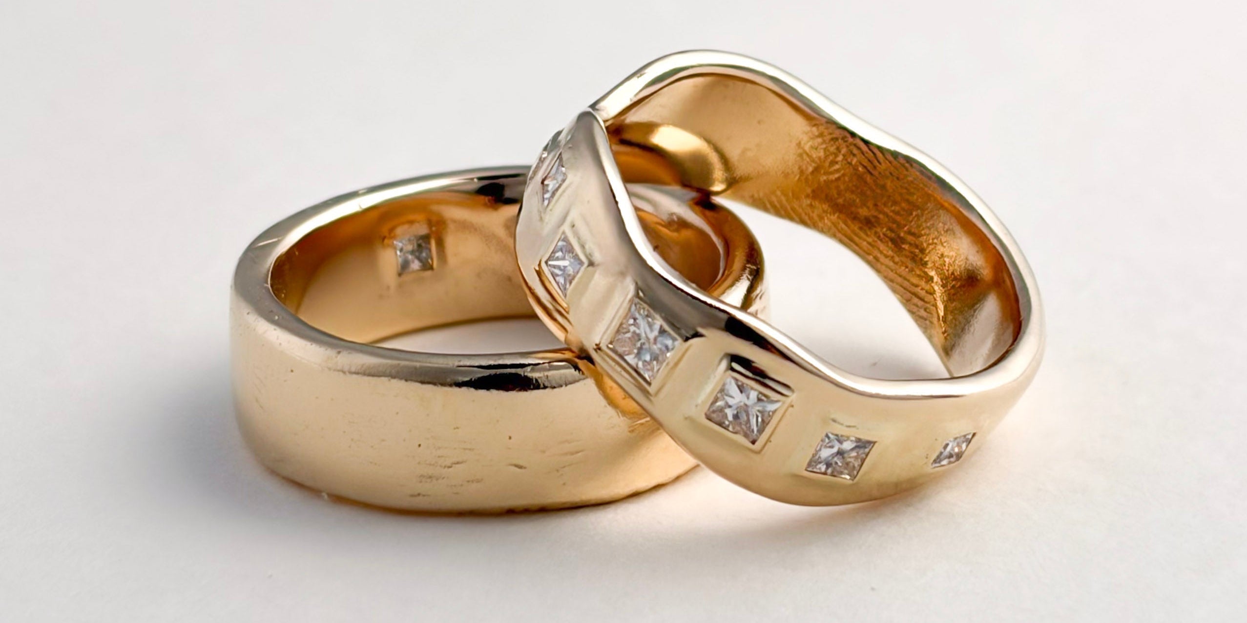 Pair of finished yellow gold wedding bands, one with inset gemstones