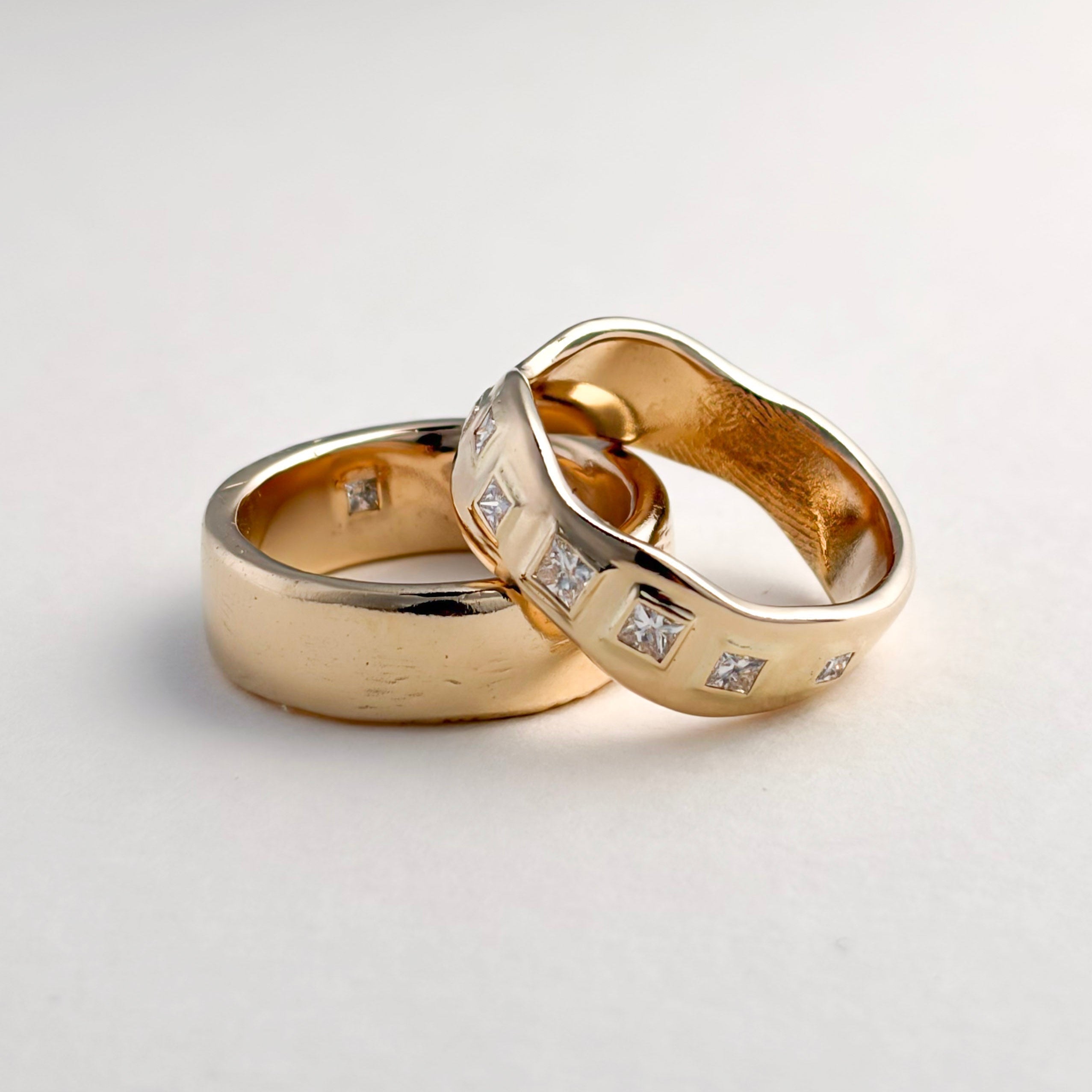 Pair of finished yellow gold wedding bands, one with inset gemstones
