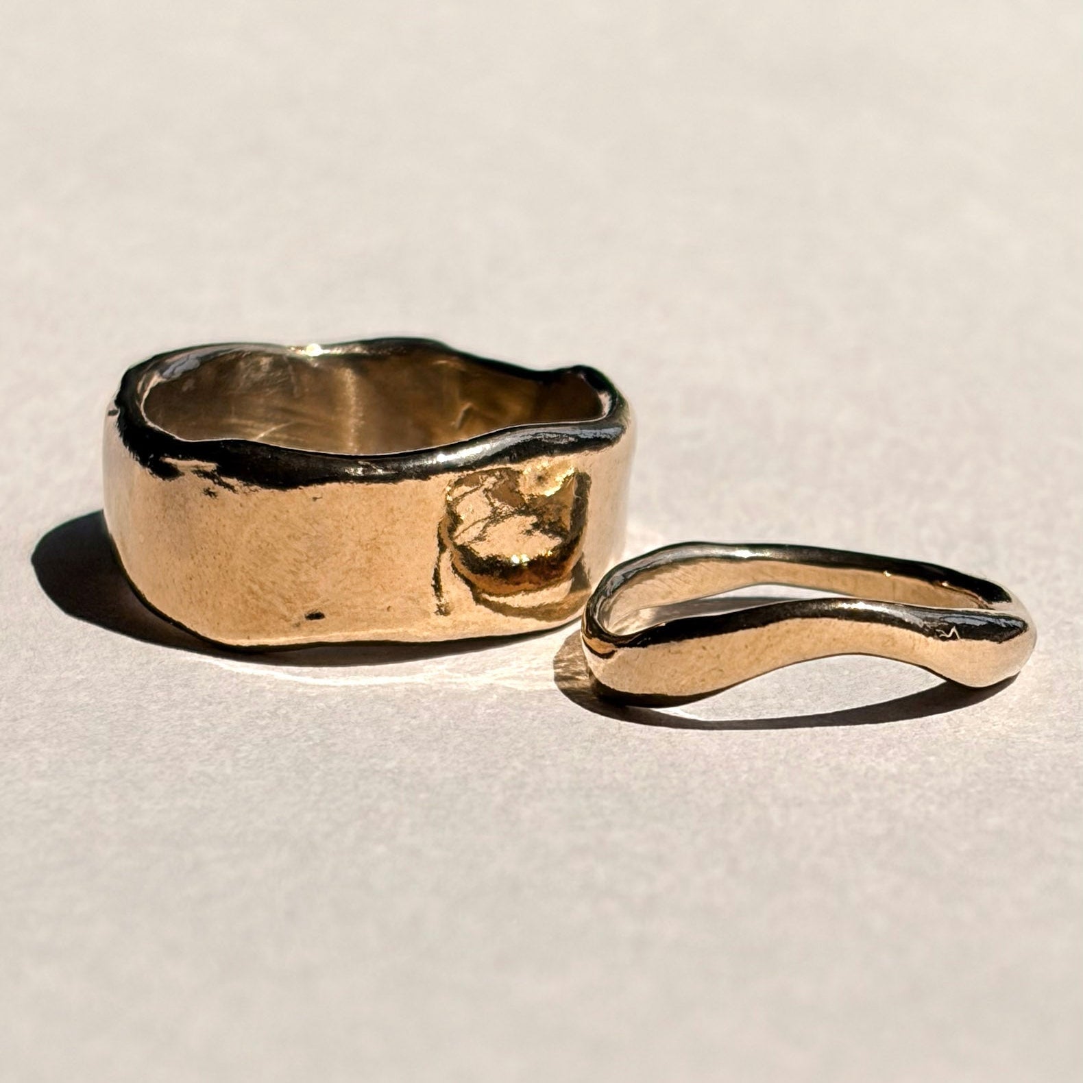 Thick and curved sculptural yellow gold wedding bands shown together