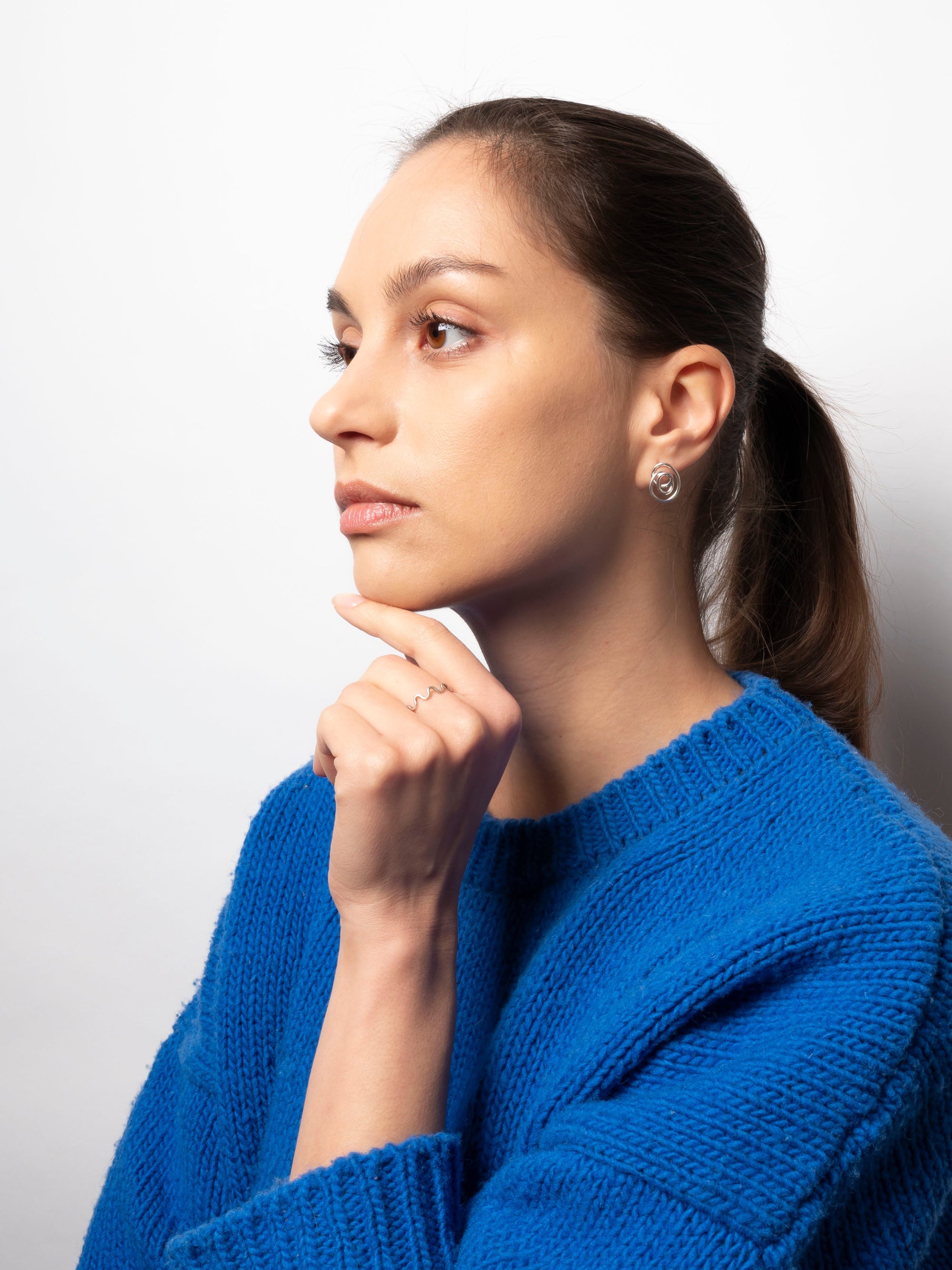 Woman wearing a blue sweater against a white background