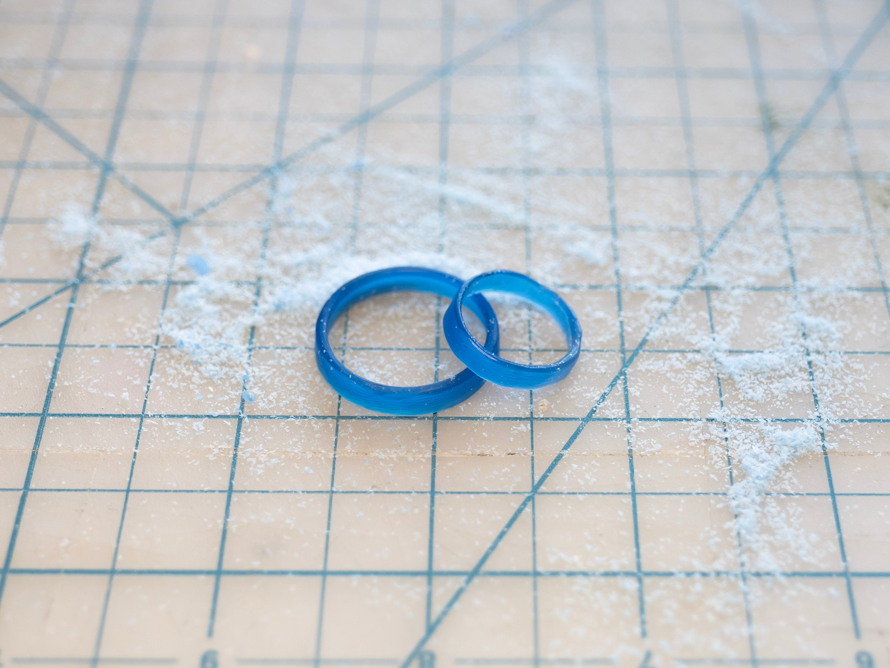 Two blue wax rings on a grid surface