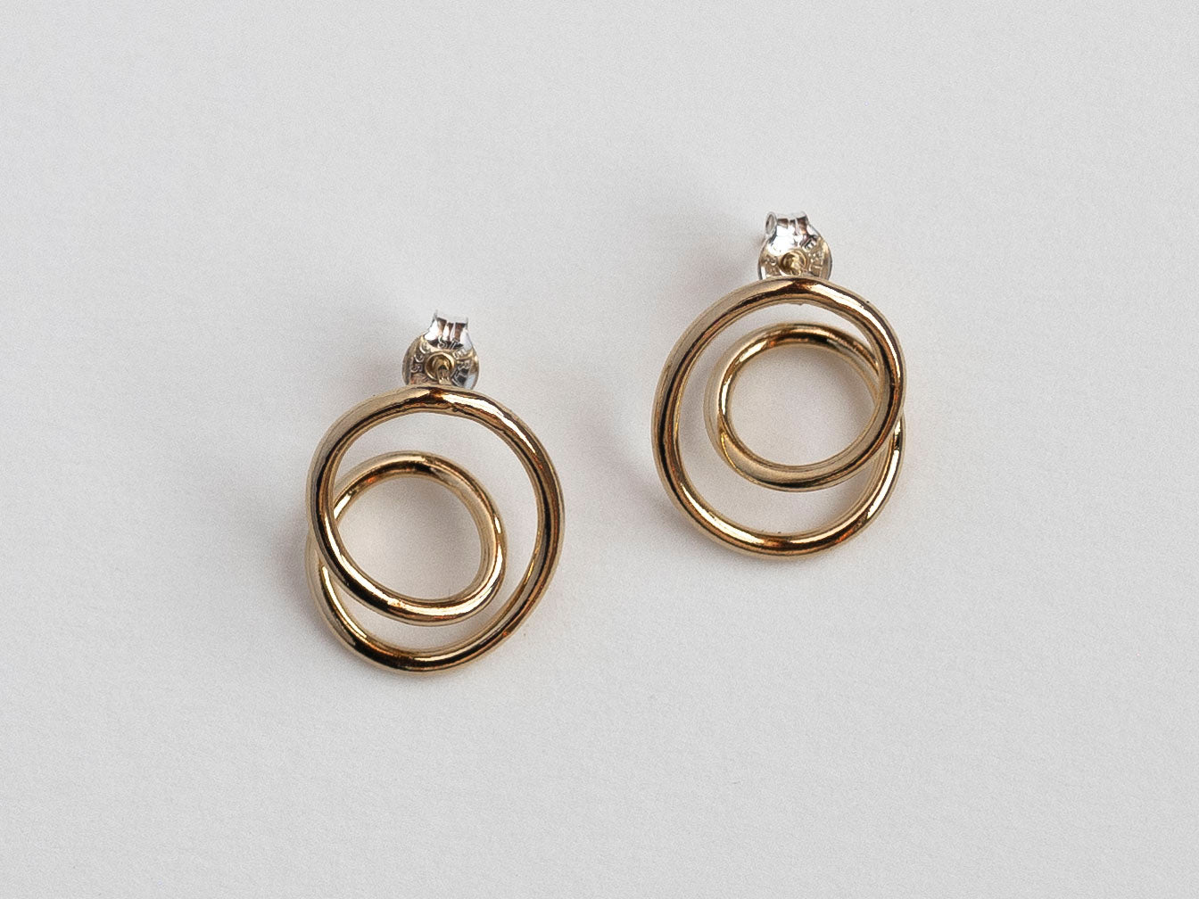 Gold hoop earrings on a light gray background