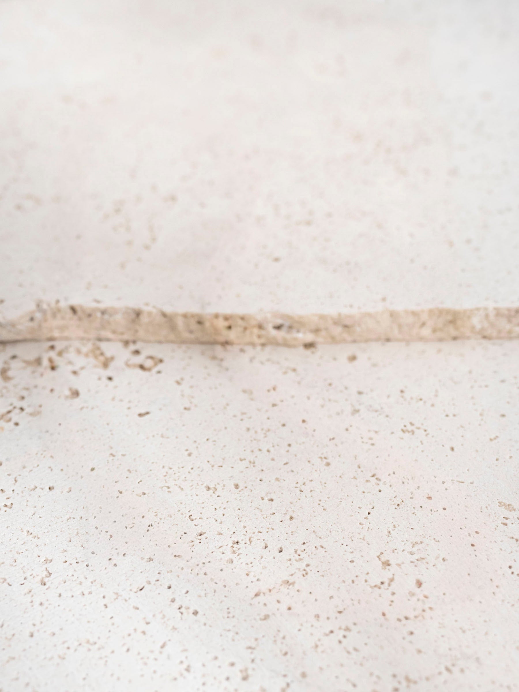 Close-up of a speckled white and beige stone surface