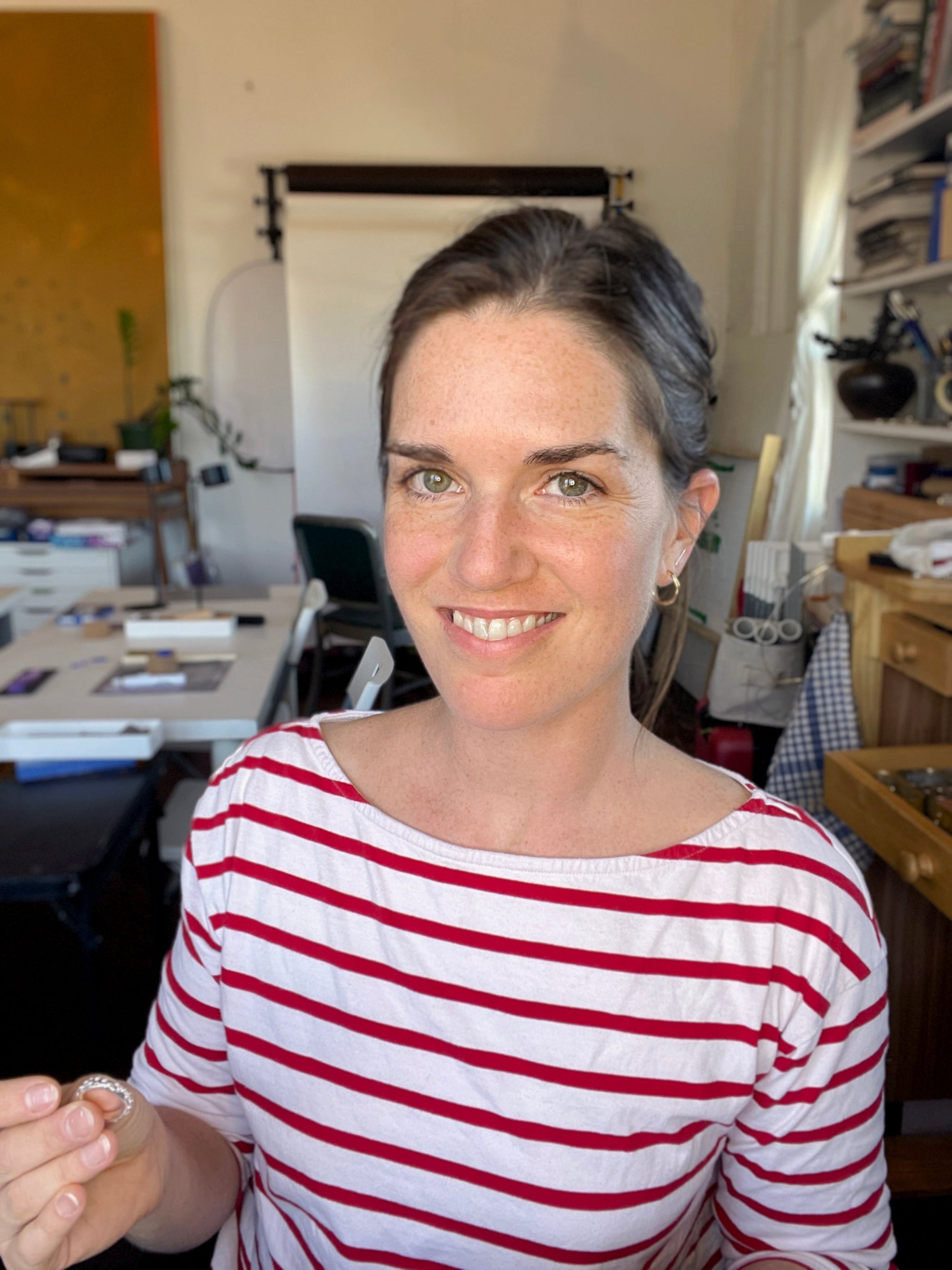 Woman wearing a red and white striped shirt in an jewelry studio setting