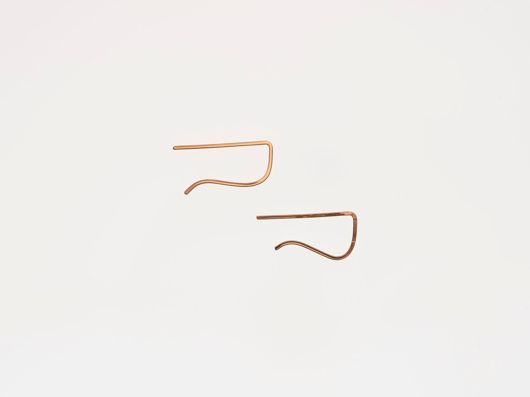 Two gold earrings on a white background