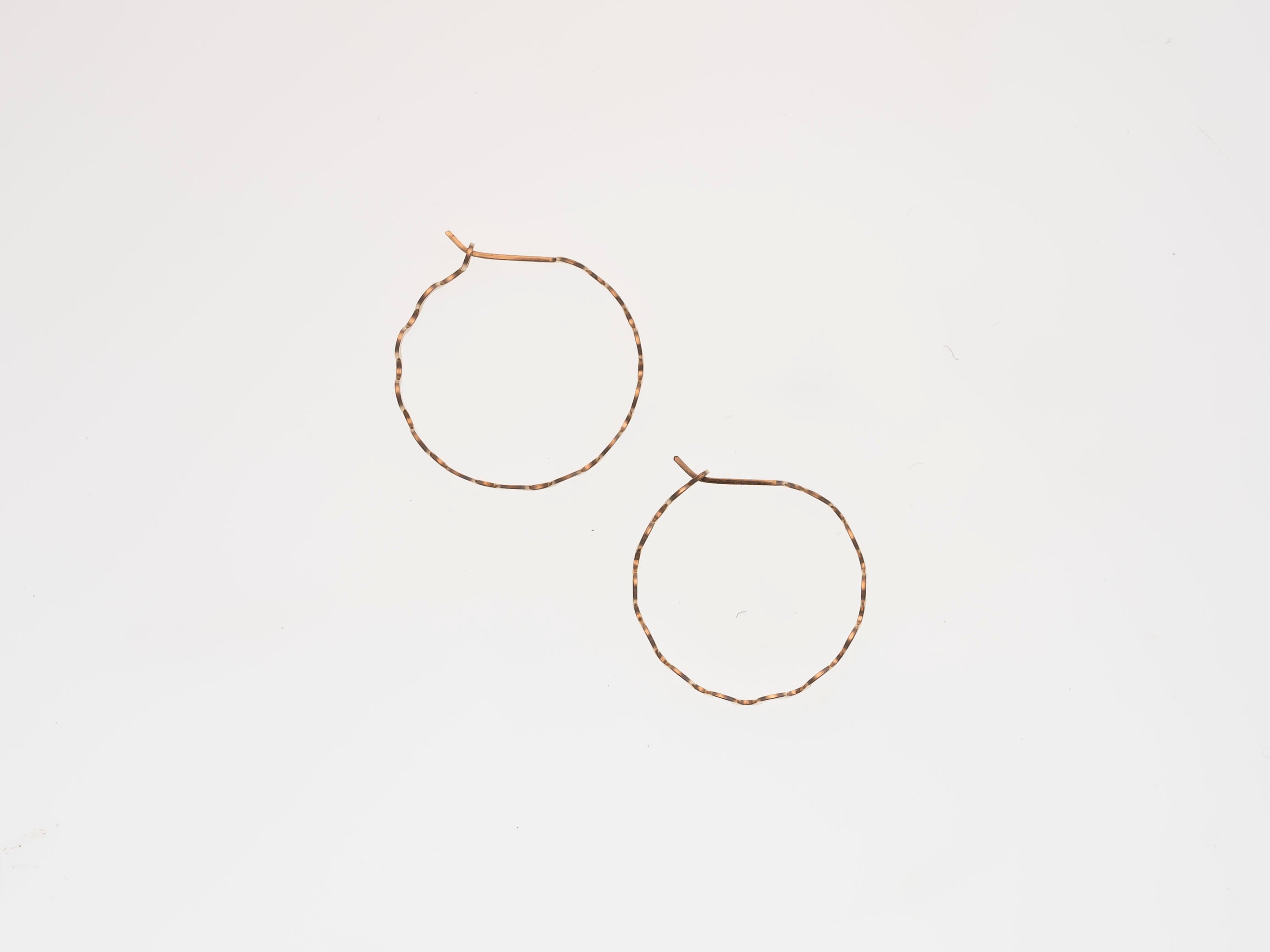 Gold hoop earrings on a light beige background