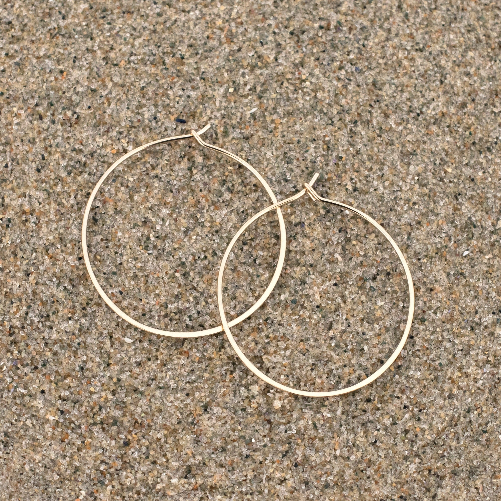 14k gold fill 1.25" hoop earrings on sand