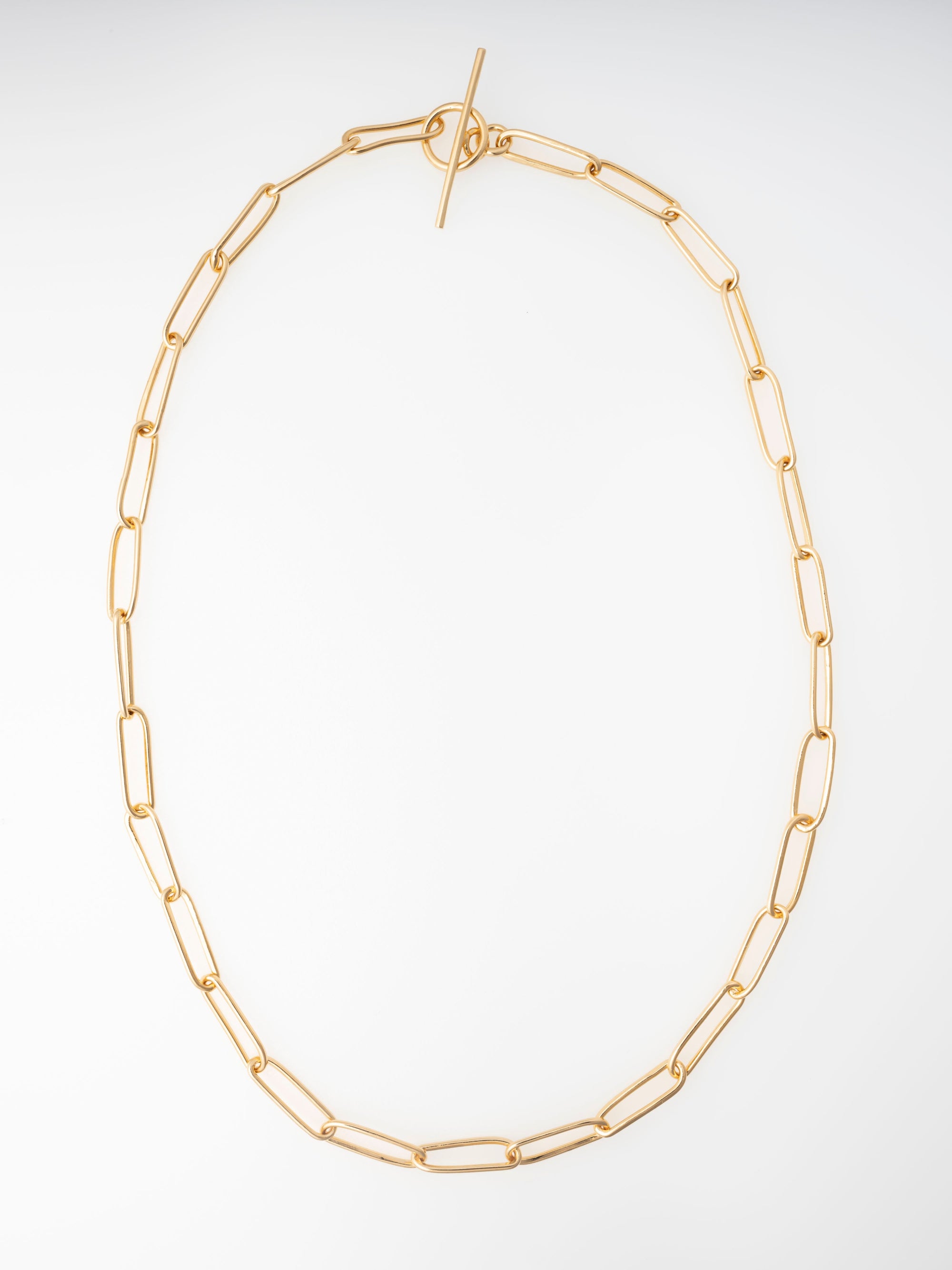 Gold chain necklace on a light gray background