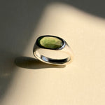 Green garnet set in a sculptural sterling silver ring, still life with shadows