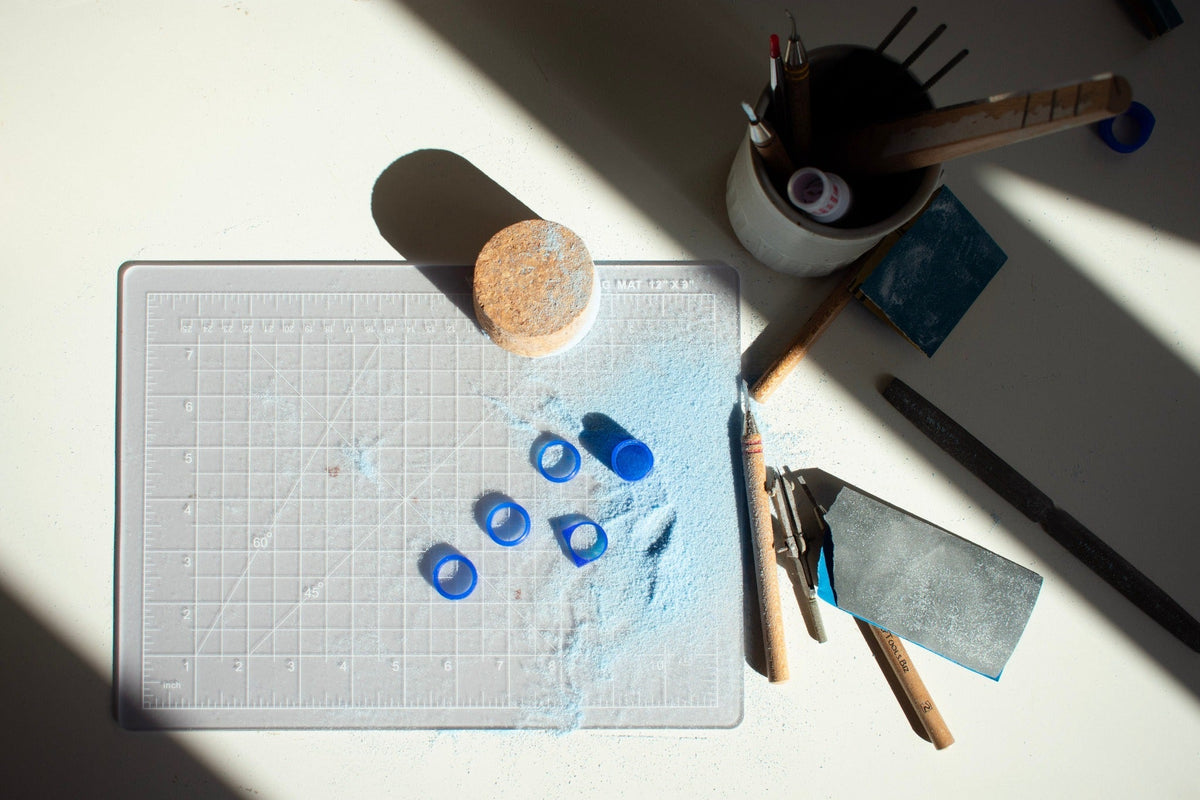 Wax ring models and jewelry carving tools arranged on a cutting mat in the RA HA studio