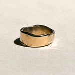Thick sculptural 14k yellow gold wedding band with organic edges, front view