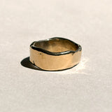 Thick sculptural 14k yellow gold wedding band with organic edges, front view