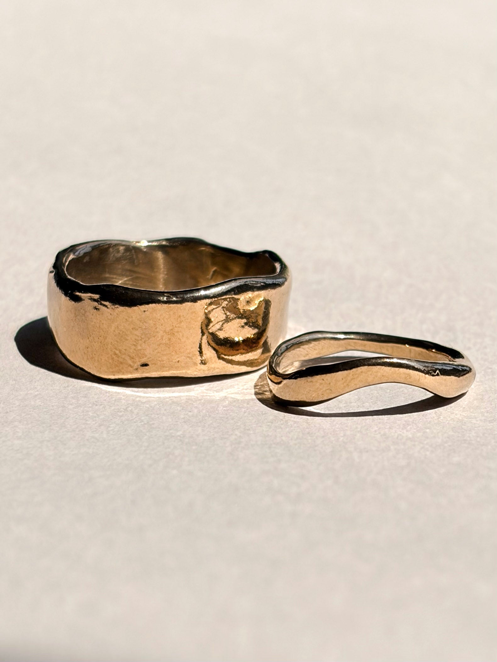 Thick and curved sculptural 14k yellow gold wedding bands shown together