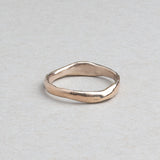Thin hand-carved 14k gold wedding band with subtle irregular texture