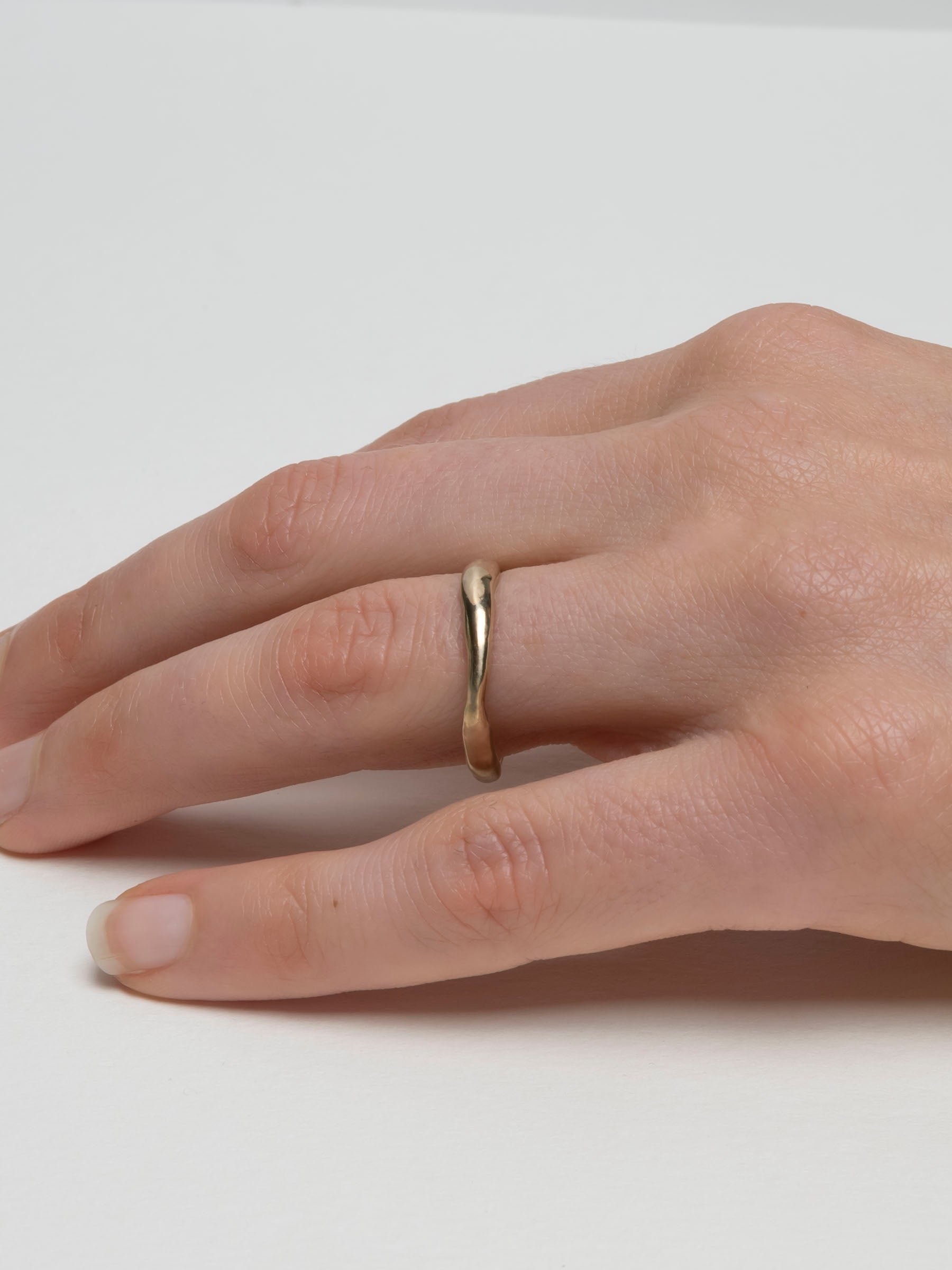 Thin 14k gold wedding band with subtle organic variation