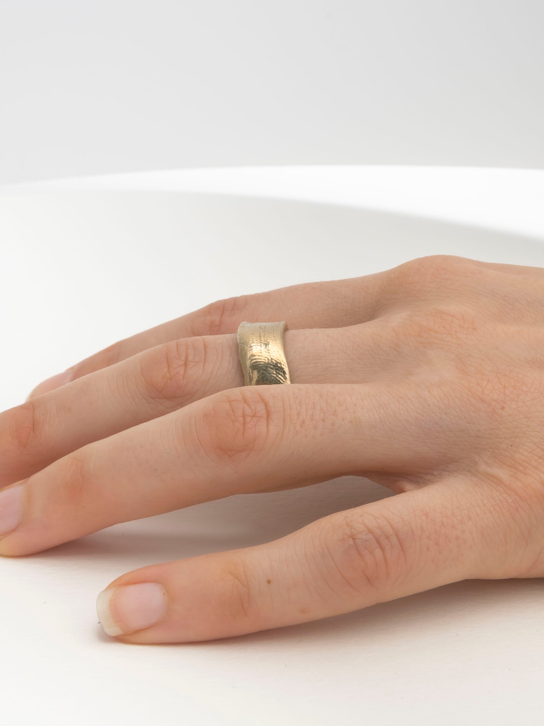 Thick hand-carved gold wedding band with textural organic finish