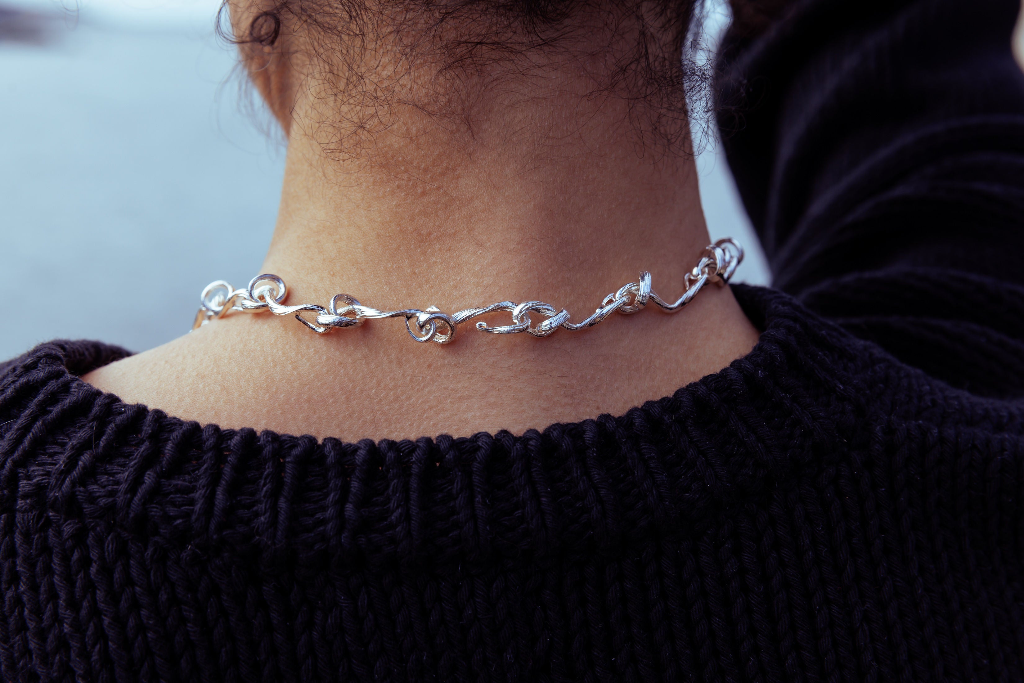 RA HA cast-link chain necklace in sterling silver, worn on body detail