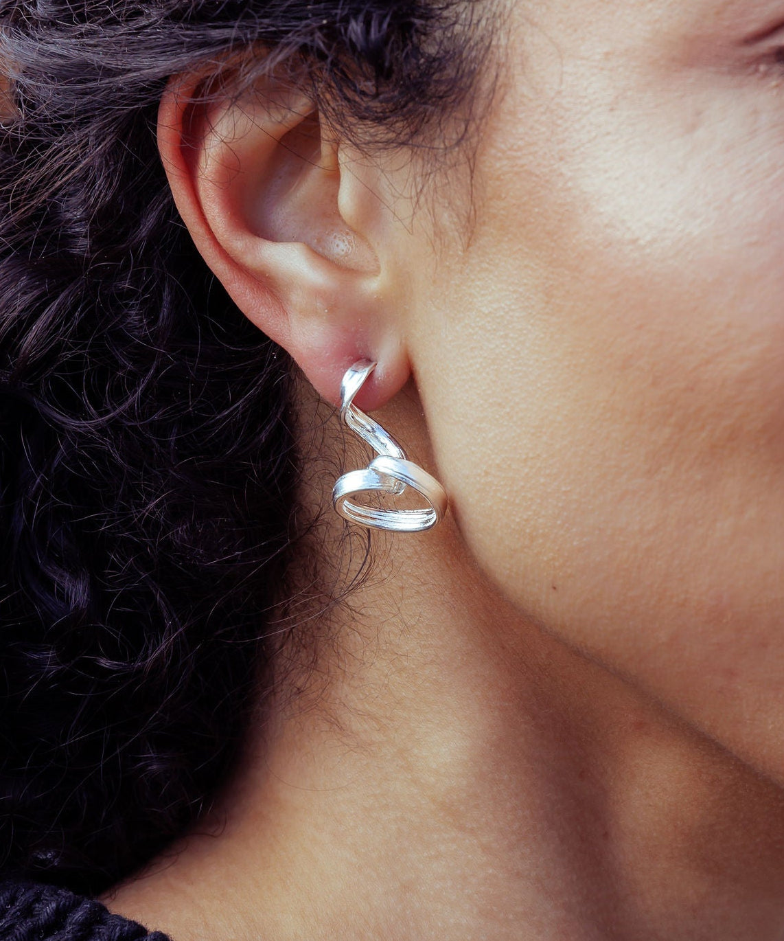 RA HA long sculptural earring in sterling silver, worn on ear