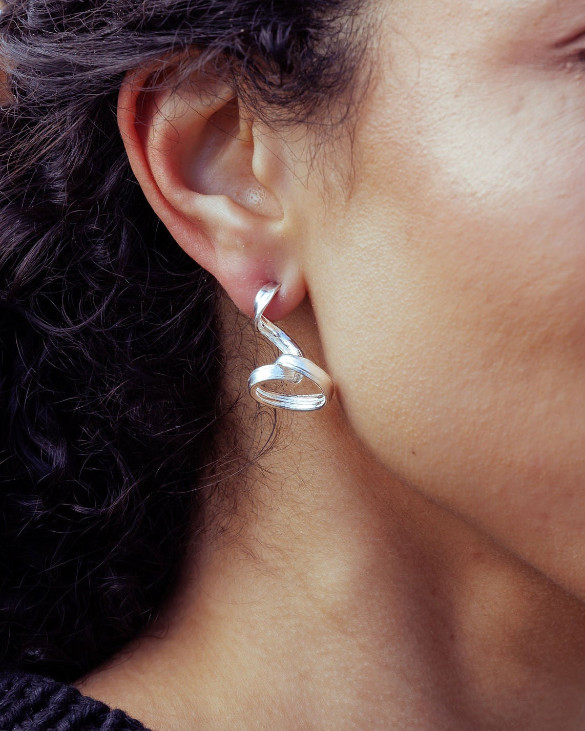 RA HA long sculptural earring in sterling silver, worn on ear