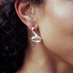 RA HA long sculptural earring in sterling silver, worn on ear