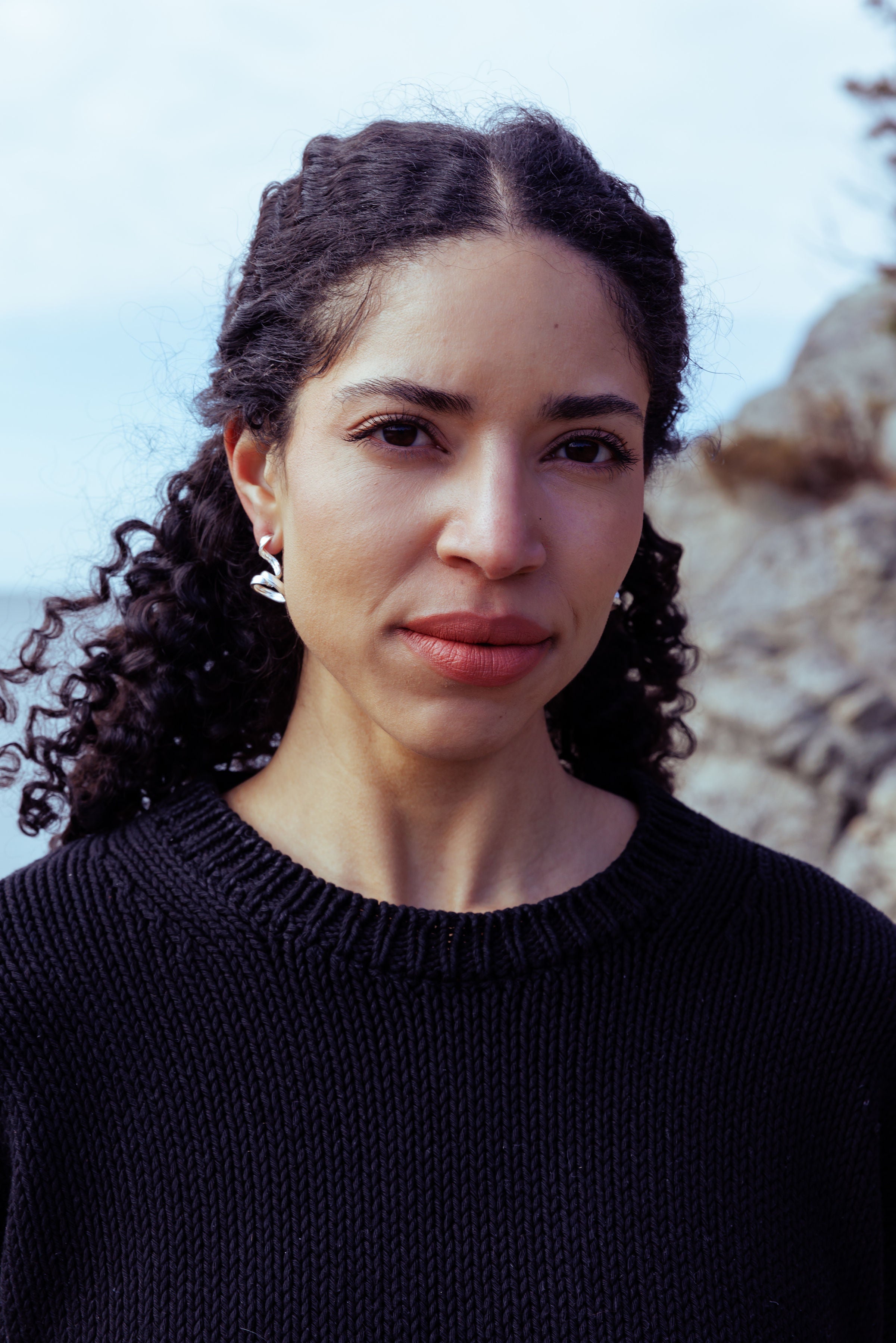 RA HA long sculptural earring in sterling silver, worn on ear