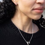 RA HA pendant necklace in sterling silver, worn on body