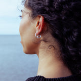 RA HA sculptural hoop earrings in sterling silver, worn on ear