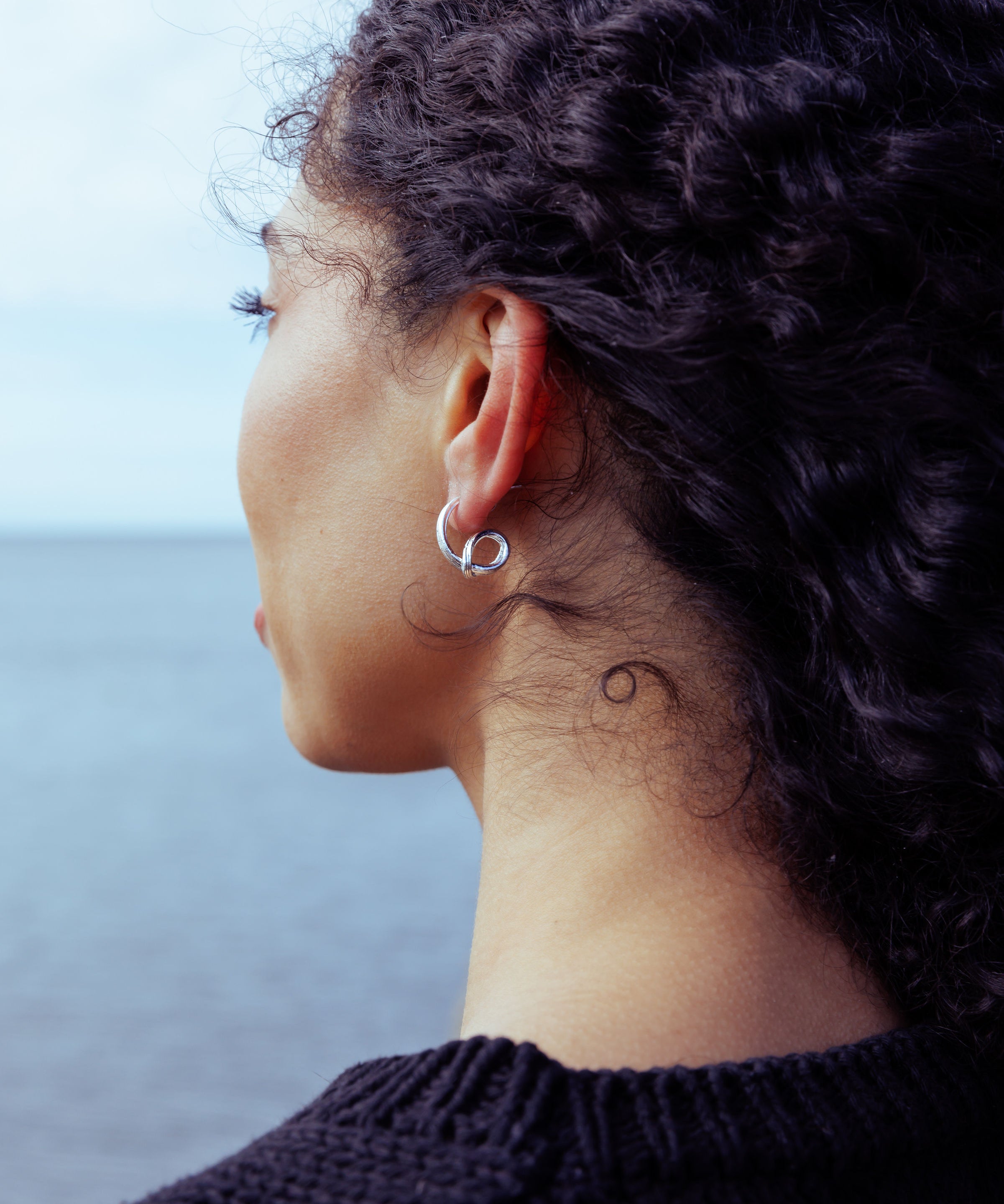 RA HA sculptural hoop earrings in sterling silver, worn on ear