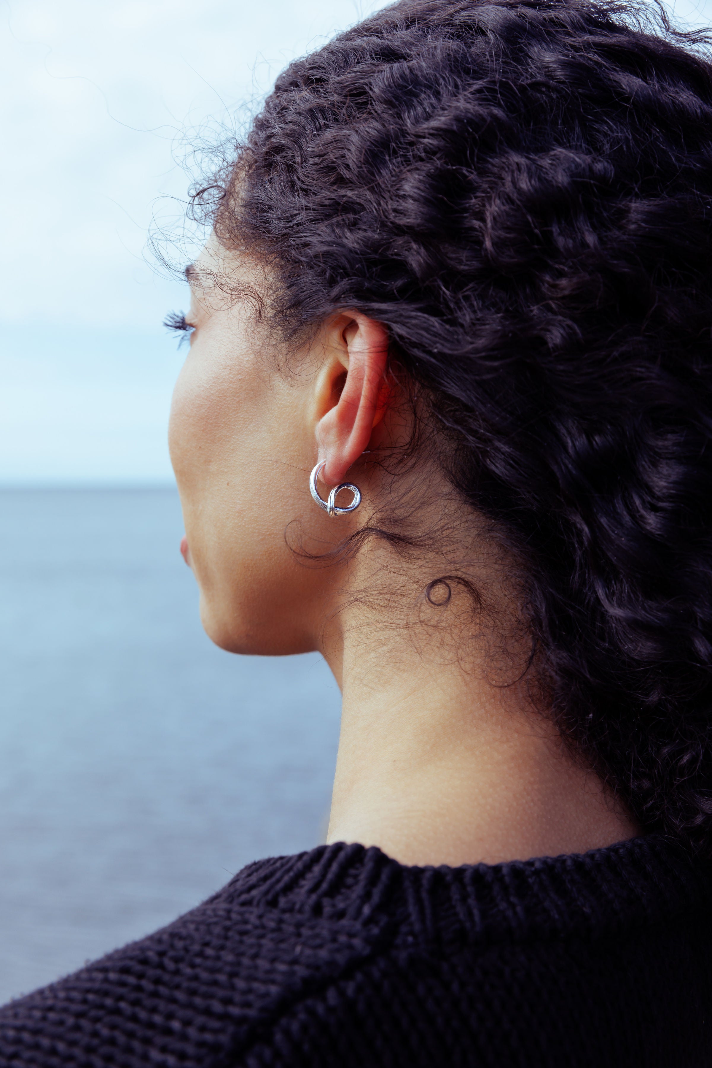 RA HA sculptural hoop earrings in sterling silver, worn on ear