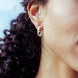 RA HA sculptural hoop earrings in sterling silver, worn on ear