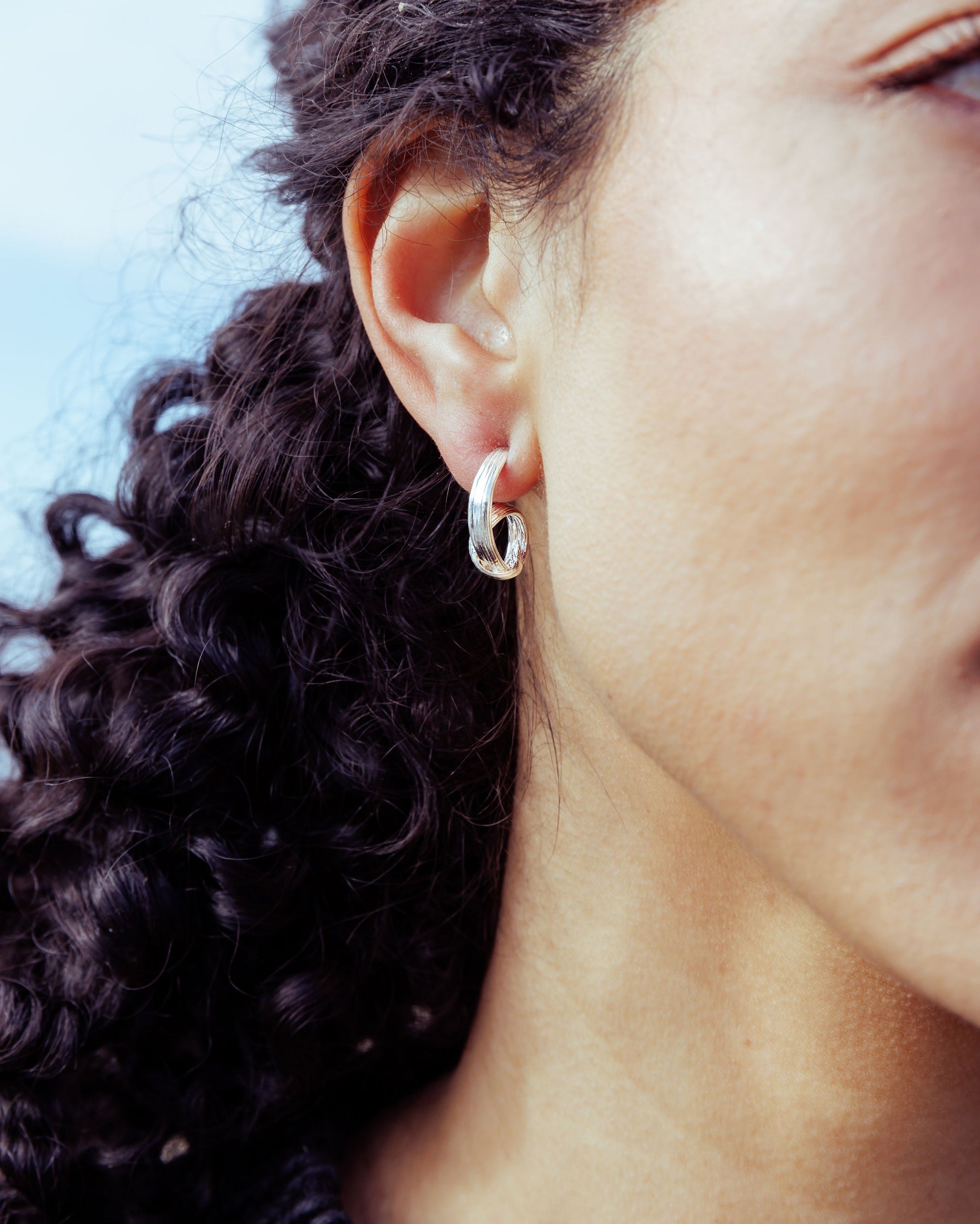 RA HA sculptural hoop earrings in sterling silver, worn on ear