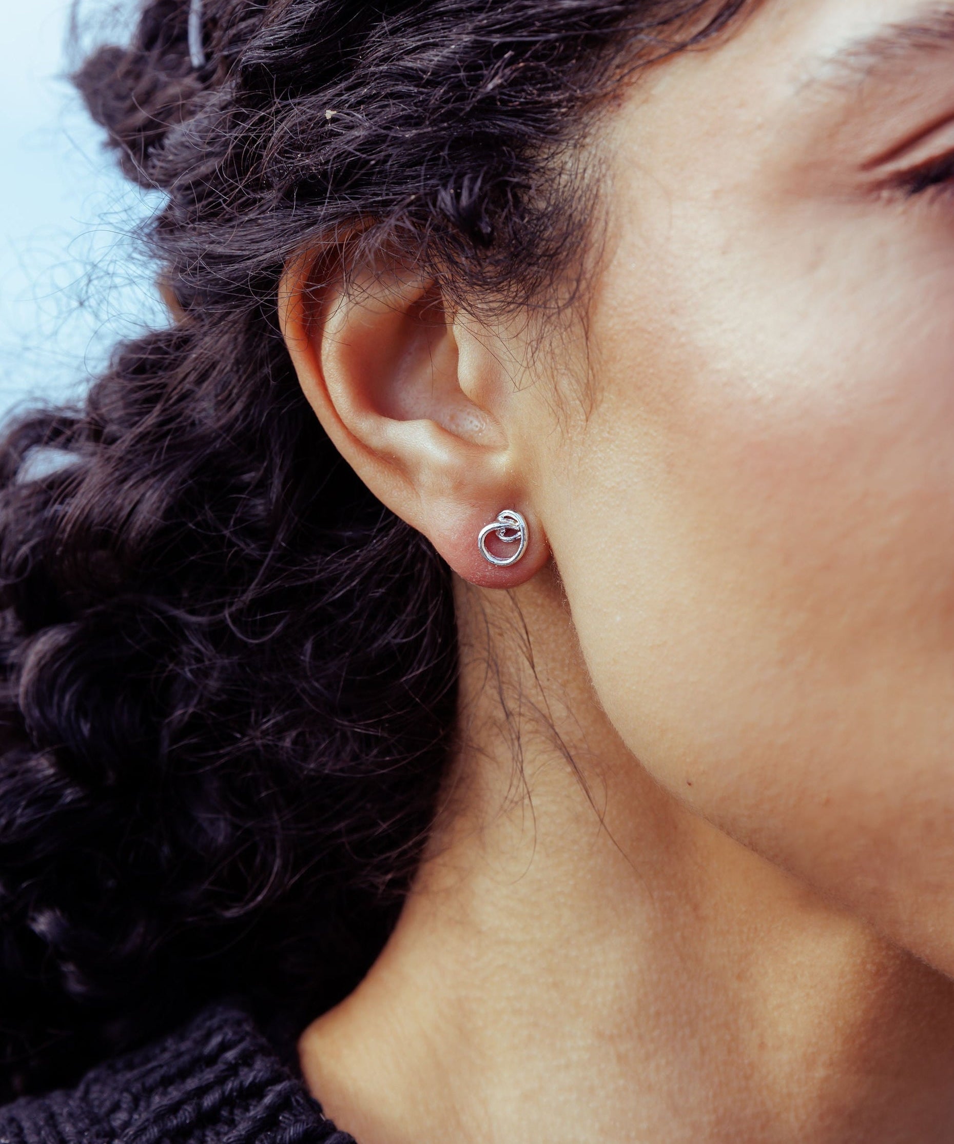RA HA sculptural stud earrings in sterling silver, worn on ear detail