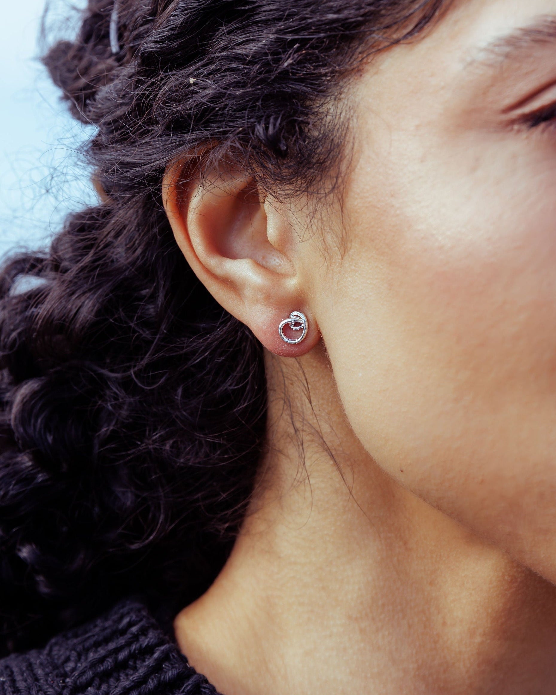 RA HA sculptural stud earrings in sterling silver, worn on ear detail