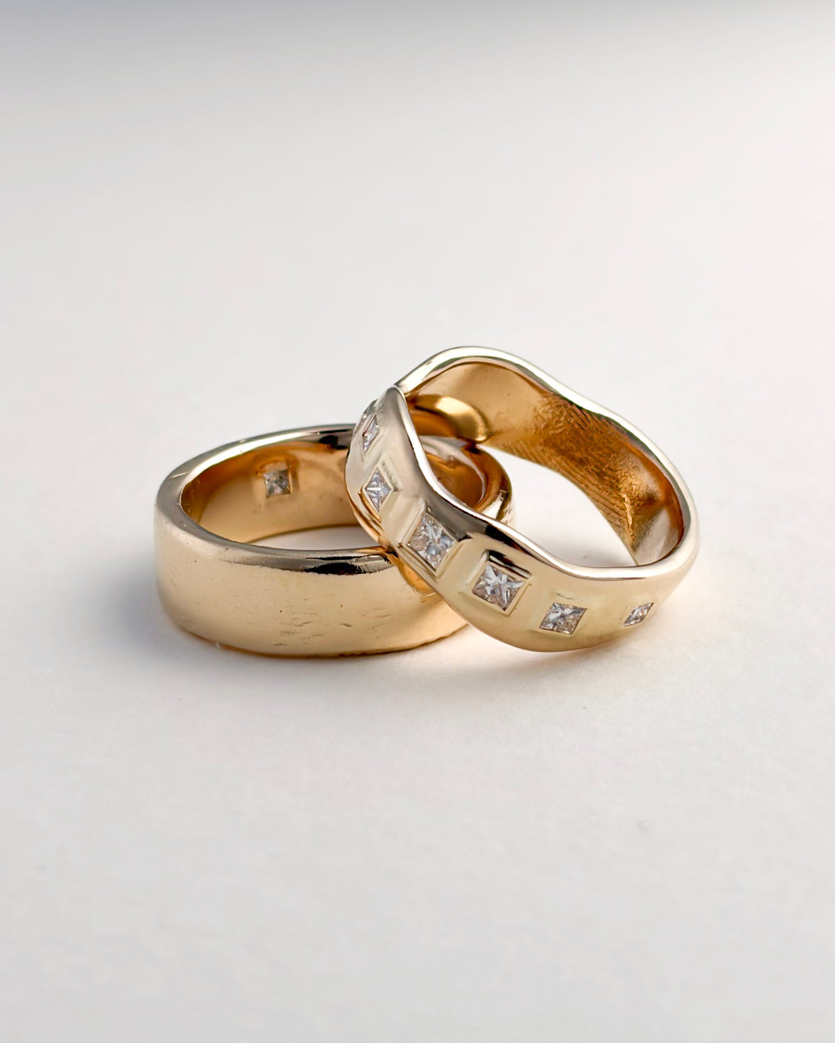 Pair of finished yellow gold wedding bands, one with inset gemstones