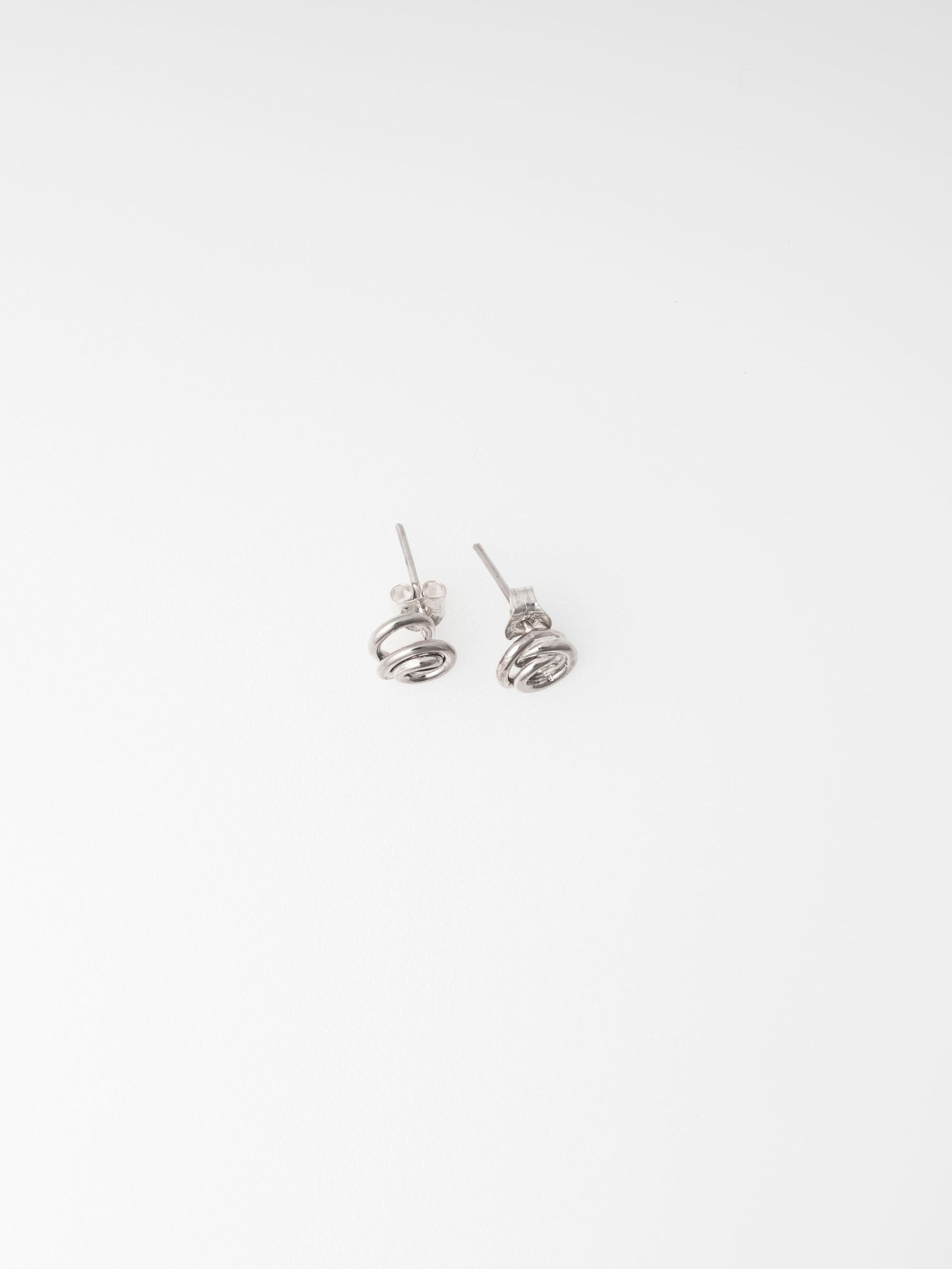 Pair of silver spiral earrings on a white background